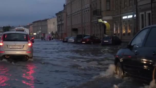 거리에 스플래시와 자동차 트래픽 아스팔트 도로에 웅덩이 비상사태 배수구는 폭우에 — 비디오