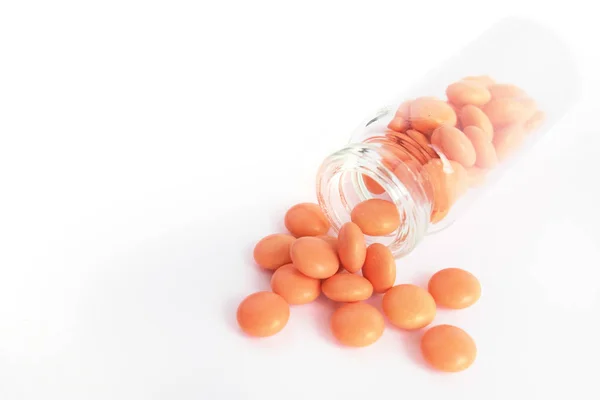Oranžové tablety ze skleněné láhve na bílém podkladu. copyspace pro text. Epidemie, léky proti bolesti, zdravotní péče, prášky na léčbu a zneužívání drog — Stock fotografie
