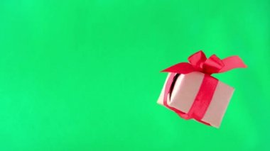 Yeşil ekranda kırmızı kurdeleli hediye kutusu. 360 derece dönüş. sorunsuz döngü. sıfır yerçekimi. Levitation. renk anahtarı. copyspace. Konsept satış, indirimli fiyat, noel tatilleri ve alışveriş