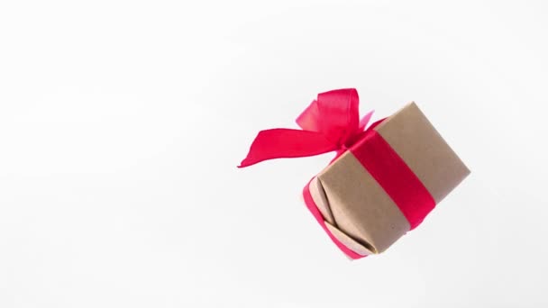 白色屏幕上旋转的红丝带礼品盒 360 度旋转 无缝循环 零重力 色度键 复制空间 概念销售 折扣价格 圣诞假期和购物 — 图库视频影像