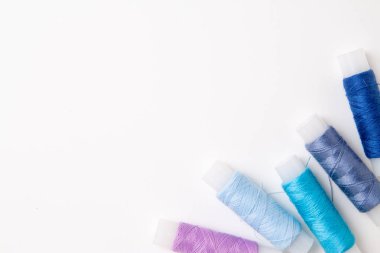Beyaz arka plan üzerinde renkli iplik bobinleri. Dikiş malzemeleri ve aksesuarlar, dikiş, dikiş, nakış. boşaltmak. düz yatıyordu. Üstten Görünüm