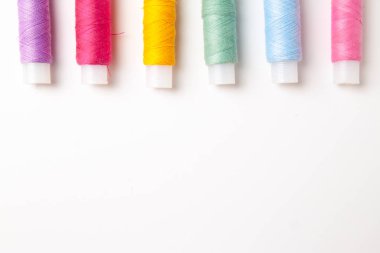 Beyaz arka plan üzerinde renkli iplik bobinleri. Dikiş malzemeleri ve aksesuarlar, dikiş, dikiş, nakış. boşaltmak. düz yatıyordu. Üstten Görünüm
