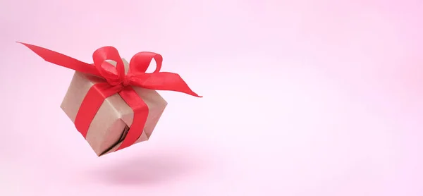 横幅与礼品盒红色丝带在粉红色的背景。悬浮。军事主义。复制空间。概念销售、购物、圣诞假期和生日 — 图库照片
