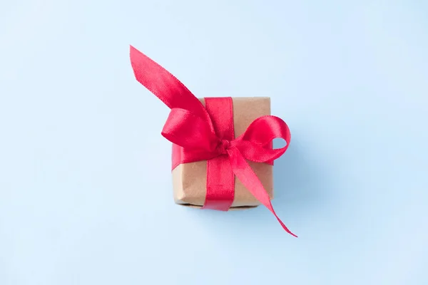 Подарункова коробка з червоною стрічкою на синьому фоні. нульова гравітація. привітання. Аліалізм. Концептуальні продажі, покупки, різдвяні свята та день народження — стокове фото