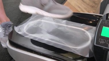 Otomatik ayakkabı kapağı dispenseri kliniği nde yürüyerek gelen ziyaretçi, Hightech polietilen ayakkabı teknolojisi.