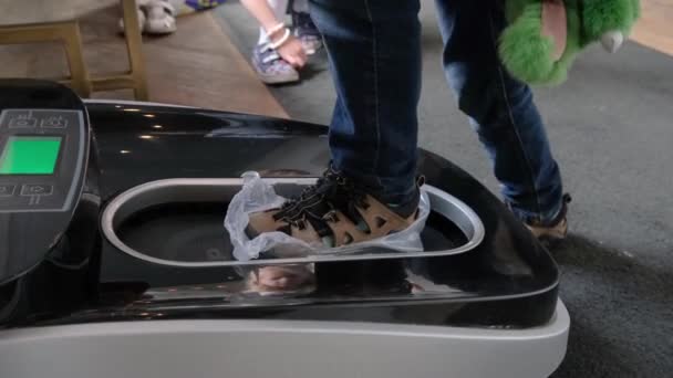 Küçük Çocuk Otomatik Ayakkabı Kapağı Dağıtıcısında Yaya Olarak Hightech Polietilen — Stok video
