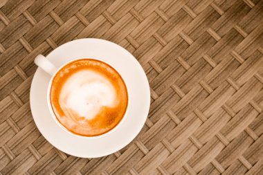 Kafede baston ahşap masada beyaz fincan Cappuccino. Üst te. Copyspace. Bewerages, kahve severler ve sabah menüsü konsepti. Şık tonlama.