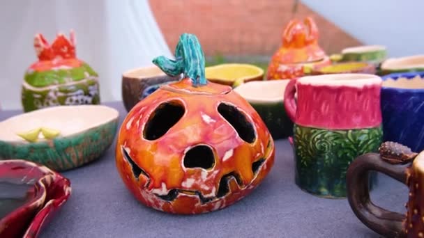 Halloween calabaza en forma de vela de cerámica jack o linterna en el mostrador de la feria festiva de Halloween . — Vídeo de stock