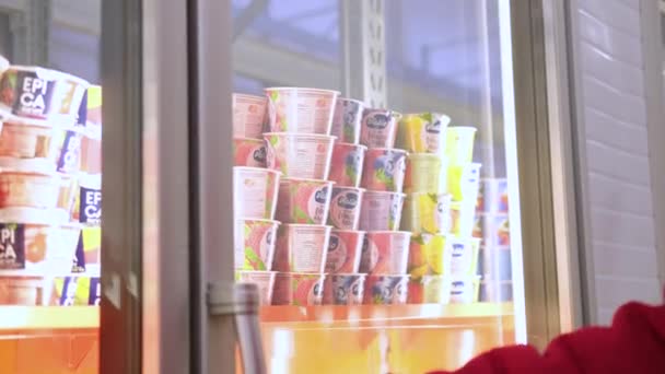 Hombres mano toma Valio yogur de la estantería de la nevera con productos lácteos en el supermercado 27.05.2020 San Petersburgo Rusia . — Vídeos de Stock