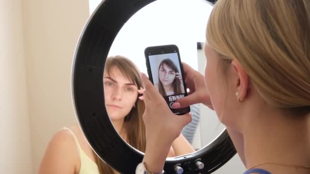4k. esthéticienne faisant la photo après coloriage sourcil de tatouage. Maquillage permanent des sourcils de la femme aux sourcils épais dans le salon de beauté . — Video