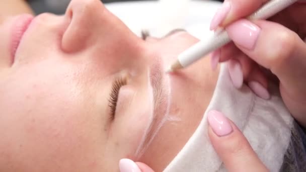 Permanent make-up for eyebrows of woman with thick brows in beauty salon. Closeup beautician doing coloring tattooing eyebrow — Stock Video