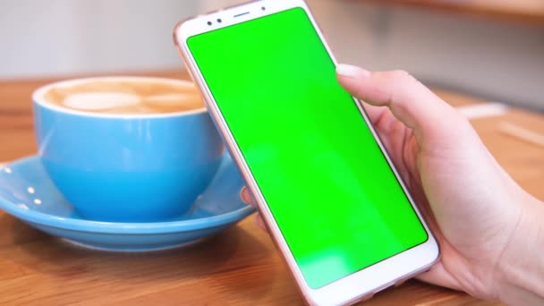 4K. mulher usando smartphone visualização de tela verde no telefone celular navegação chroma chave on-line assistindo desfrutar de beber café leitura de mídia social fechar as mãos. Compras na Internet . — Vídeo de Stock