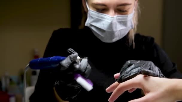 4k. Hårdvara Manikyr med hjälp av elektrisk enhet maskin. förfarande för beredning av naglar innan nagellack appliceras. Hands of Manicurist i svarta handskar och naglar av klient. Kvinna i skönhetssalong — Stockvideo