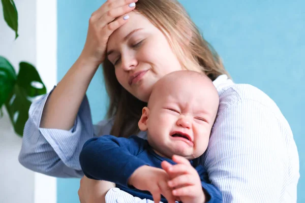 Mamãe cansada tentando acalmar seu bebê chorando. Criança de birra recém-nascida nas mãos da mãe. Vida familiar, maternidade — Fotografia de Stock