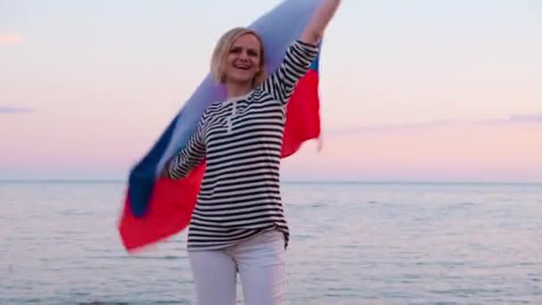 4k.Happy žena v letním oblečení mává národní Rusko vlajky venku moře západ slunce - ruská vlajka, země, vlastenectví, Rusko den 12. červen. — Stock video