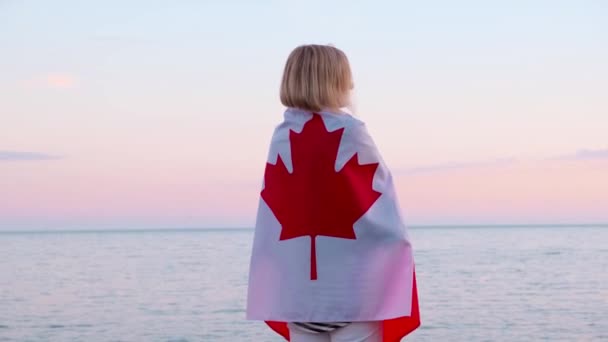 4k.Back mulher vista em roupas de verão com bandeira nacional do Canadá ao ar livre mar por do sol - bandeira do Canadá, país, patriotismo, dia da independência e conceito de pessoas . — Vídeo de Stock