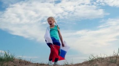 Sarışın kız yazın mavi gökyüzünde ulusal Rusya bayrağını sallayarak eğleniyor. Rus bayrağı, ülke, vatanseverlik, 12 Haziran Rusya günü..