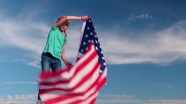 4 bin. Sarışın kız yazın mavi gökyüzünde ulusal bayrak sallıyor. Amerikan bayrağı, ülke, vatanseverlik, bağımsızlık günü 4 Temmuz..