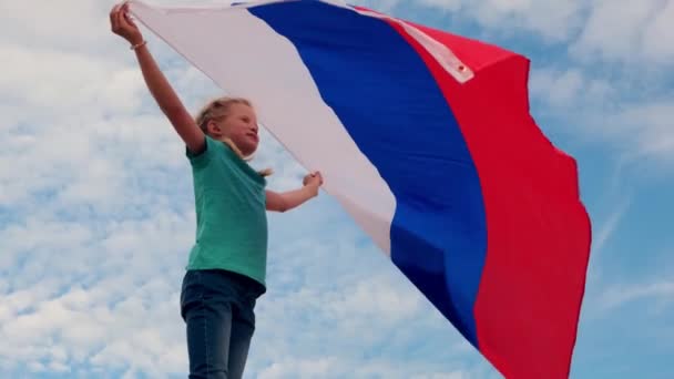 4k.Blond meisje zwaaien nationale Rusland vlag buiten boven de blauwe hemel in de zomer - Russische vlag, land, patriottisme, Rusland dag 12 juni. — Stockvideo