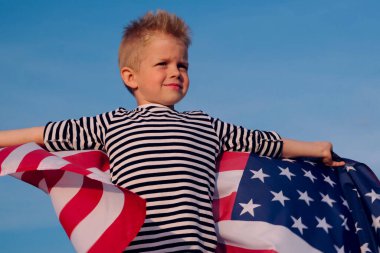 Sarışın çocuk yazın mavi gökyüzünde ulusal Amerikan bayrağı sallıyor - Amerikan bayrağı, ülke, vatanseverlik, bağımsızlık günü 4 Temmuz.