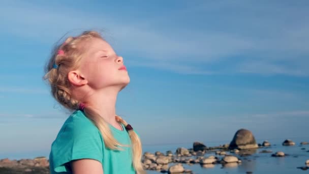 4k. Uvolněná dívka dýchá čerstvý vzduch přes modrou oblohu na moři v létě. Snění, svoboda a pojetí cestování — Stock video