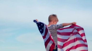 4 bin. Mutlu küçük çocuk yazın mavi gökyüzünde Amerikan bayrağı sallıyor. Amerikan bayrağı sallıyor, ülke, vatanseverlik, bağımsızlık günü 4 Temmuz..