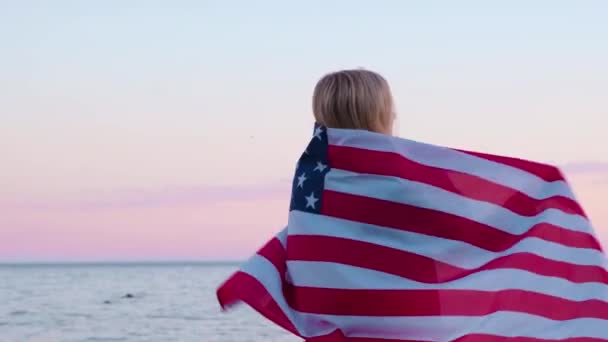 4k.Back mulher vista em roupas de verão com bandeira nacional dos EUA ao ar livre oceano por do sol - bandeira americana, país, patriotismo, dia da independência e conceito de pessoas . — Vídeo de Stock