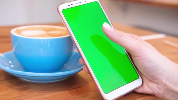 4K. mulher usando smartphone visualização de tela verde no telefone celular navegação chroma chave on-line assistindo desfrutar de beber café leitura de mídia social fechar as mãos. Compras na Internet . — Vídeo de Stock