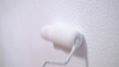 4 bin. Kadın ellerinin duvar kâğıdını beyaza boyarken boya silindiri kullanması, kapalı alanda çalışması. Ev dekorasyonu.
