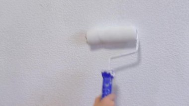 4 bin. Duvarkağıdını beyaza boyarken boya silindiri kullanan çocukların yakın çekimleri, kapalı alanda çalışmalar. Ev dekorasyonu.