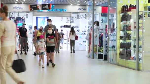 Mensen met een medisch beschermend masker lopen in het winkelcentrum. Zomer stad dag. Sint-Petersburg Rusland 26jun2020 — Stockvideo