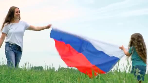 4k. Ευτυχισμένη μητέρα και κόρη κυματίζει εθνική σημαία της Ρωσίας σε εξωτερικούς χώρους πράσινο γρασίδι το καλοκαίρι - ρωσική σημαία, χώρα, πατριωτισμός, Ρωσία ημέρα και 12 Ιούνη. — Αρχείο Βίντεο