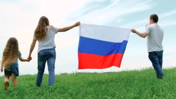 4k. Feliz familia madre padre y dos niños niña y niño pequeño ondeando bandera nacional de Rusia al aire libre va sobre hierba verde cielo azul en verano bandera rusa, país, patriotismo, día de Rusia — Vídeos de Stock