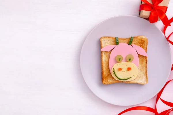 Sandwich drôle avec symbole comestible de 2021 taureau vache faite de pain grillé, saucisse et fromage. Idée de petit déjeuner pour les enfants. Nouvel An Noël nourriture vue de dessus. fête, fête, art culinaire — Photo
