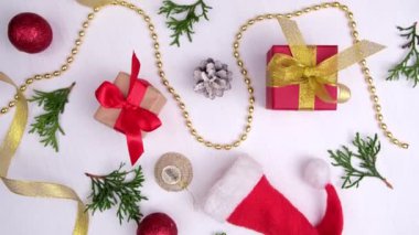 Noel arkaplanının dönüşü. Kırmızı altın kurdeleli hediye kutuları tatil süslemeleri, beyaz ahşap üzerinde noel topları. 360 derece dönüş. Kusursuz döngü. Satış, alışveriş ve kutlama kavramları