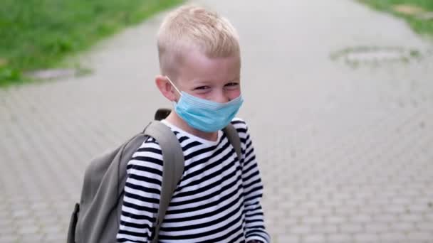 4k enfants caucasiens masqués dans la rue. Blonde écolier enfant avec sacs à dos jouer après l'école — Video