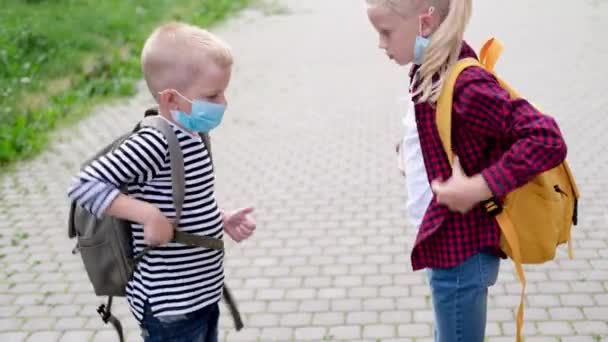 4k Kaukasische kinderen met masker. Blond zusje recht broer gezichtsmasker. Kinderen met rugzakken op straat — Stockvideo