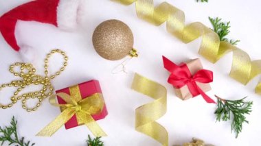 Noel arkaplanının dönüşü. Kırmızı altın kurdeleli hediye kutuları tatil süslemeleri, beyaz ahşap üzerinde noel topları. 360 derece dönüş. Kusursuz döngü. Satış, alışveriş ve kutlama kavramları