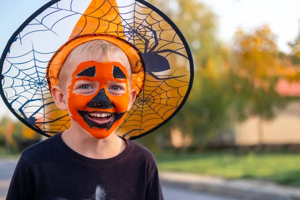 Niños de Halloween. Retrato Niño risueño con mascarilla de calabaza en traje de bruja sombrero con cubo de caramelo en la calle —  Fotos de Stock