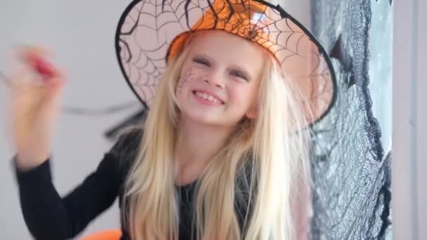 4k. Halloween kinderen. Portret blond meisje in heksenkostuum thuis. Klaar voor de vakantie — Stockvideo