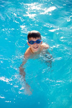 Mutlu küçük çocuk gülümseme açık yüzme havuzunda