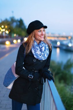 Mutlu genç moda esmer beyaz kadın akşam şehirde yürüyüş kış şapkalı