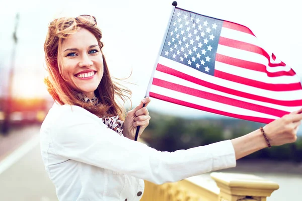 年轻的爱国心强的女人，带着灿烂的笑容，在阳光下张扬着乌萨之旗 — 图库照片