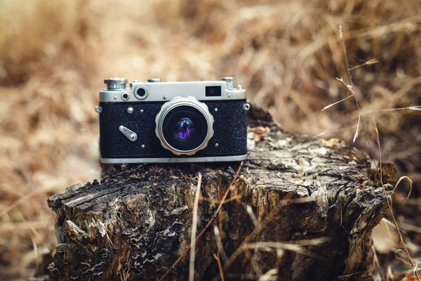 Old analog camera on wooden background.