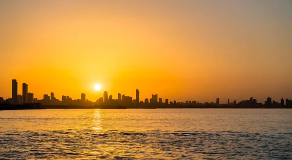 Skyline van Koeweit stad bij zonsondergang. — Stockfoto