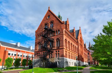 Vermont Vermont Üniversitesi 'nde Williams Hall, kırmızı tuğlalı Romanesk Diriliş mimarisi, kemerli pencereler, engelli çatı ve kampüs yeşilliği ile
