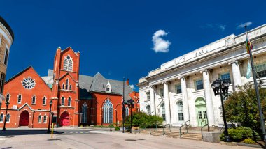 Tarihi kırmızı tuğla Birinci Birleşik Metodist Kilisesi Pittsfield, Massachusetts, ABD 'de güneşli bir günde belediye binasının klasik mimarisinin yanında duruyor.