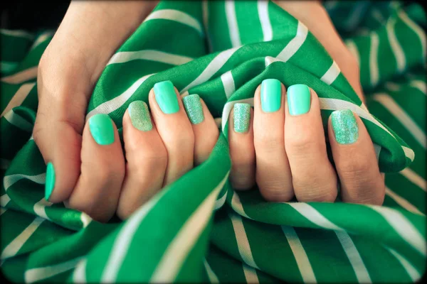 Beautiful  nail polish in hand, close-up, green nail art manicure