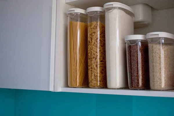 Stocked kitchen pantry with food - pasta, buckwheat, rice and su