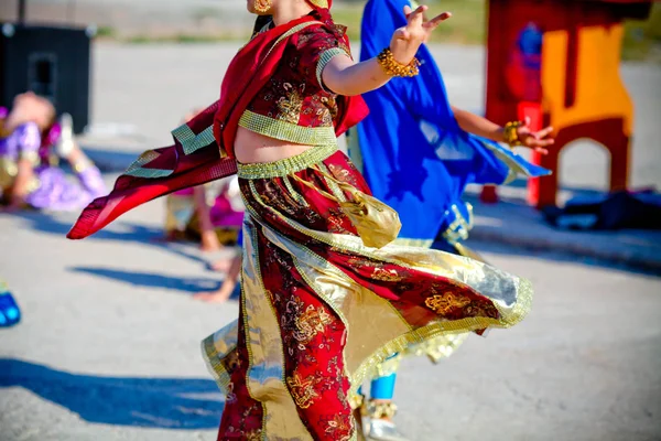 Close up of the woman dancing oriental dances in it is red gold dresses.